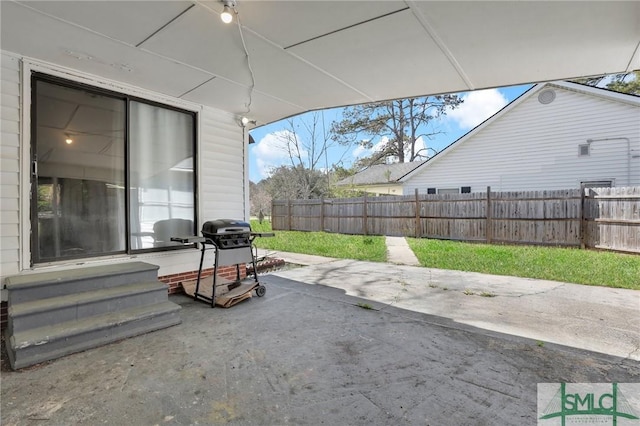 view of patio featuring entry steps, fence, and a grill