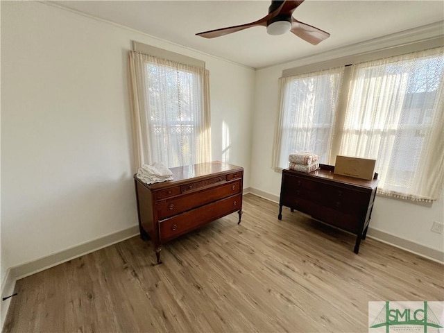 sitting room with light wood-style flooring, a ceiling fan, and baseboards