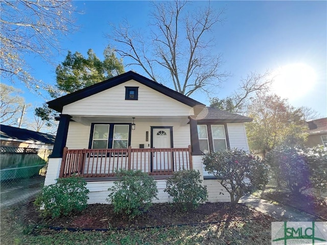 bungalow-style house featuring a porch and fence