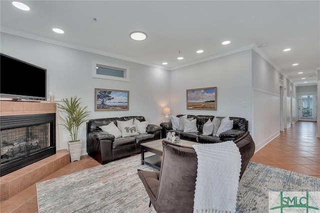 living area with tile patterned flooring, recessed lighting, a tiled fireplace, and ornamental molding