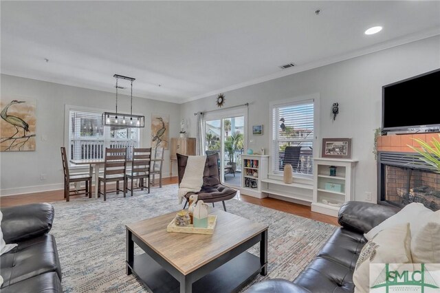 living room featuring visible vents, ornamental molding, wood finished floors, recessed lighting, and baseboards