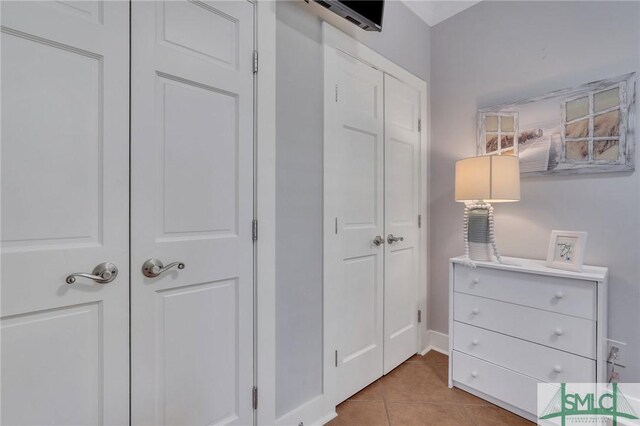 bedroom with light tile patterned flooring and a closet