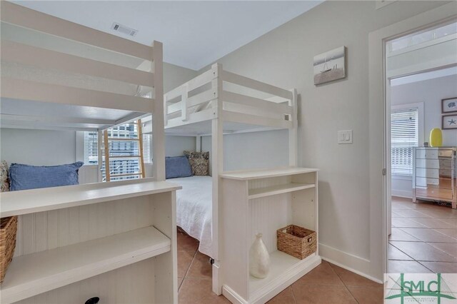 tiled bedroom featuring baseboards and visible vents