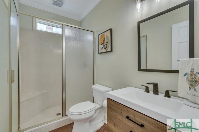 bathroom with a stall shower, toilet, crown molding, and vanity