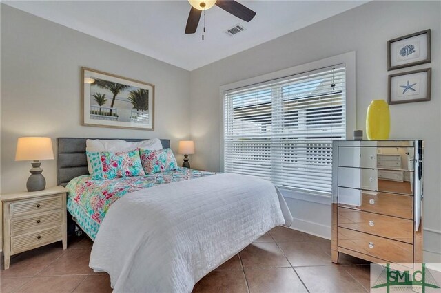 tiled bedroom with visible vents, baseboards, and a ceiling fan