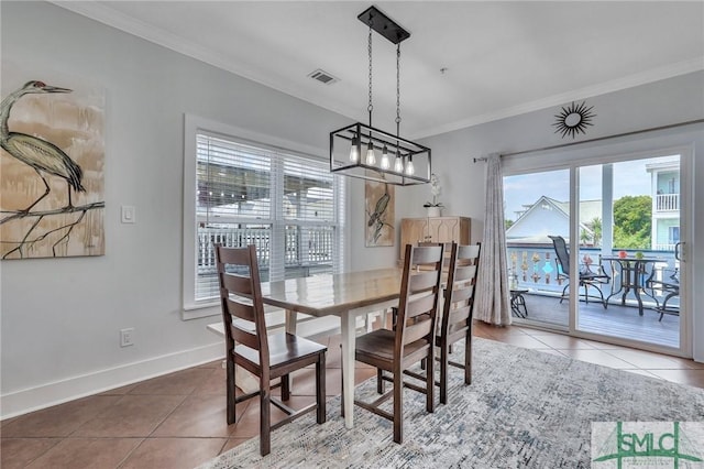 tiled dining space with visible vents, baseboards, and ornamental molding