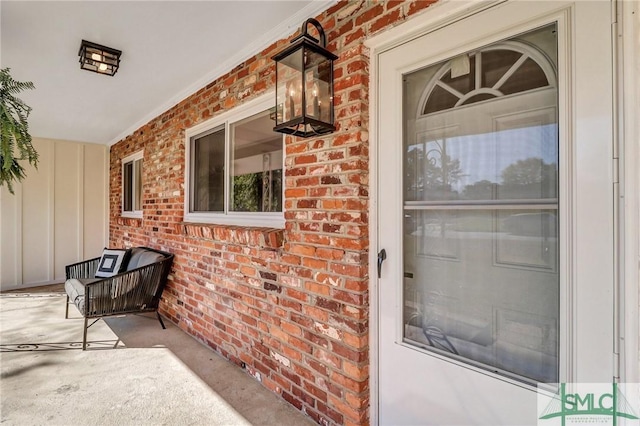 property entrance featuring brick siding and covered porch