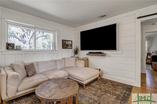 living area with visible vents and wood finished floors