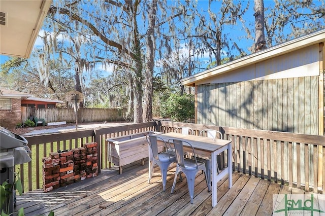 deck with outdoor dining area and fence