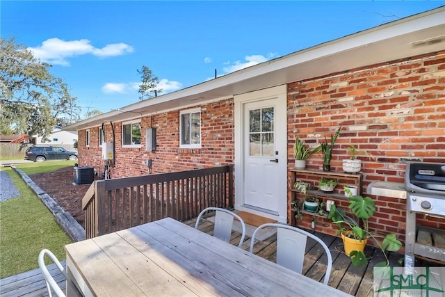 wooden deck featuring outdoor dining area and a grill