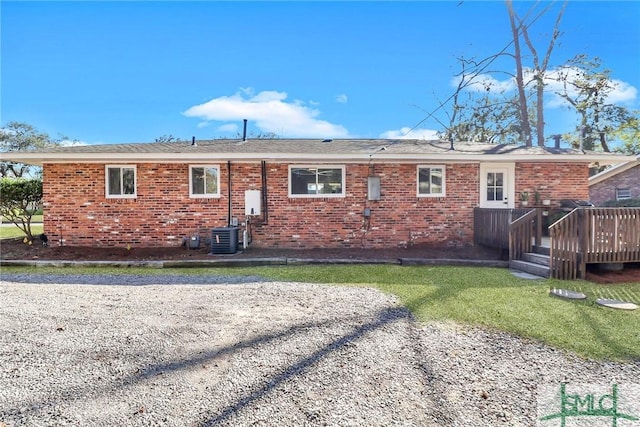 back of property with a lawn, brick siding, and a wooden deck