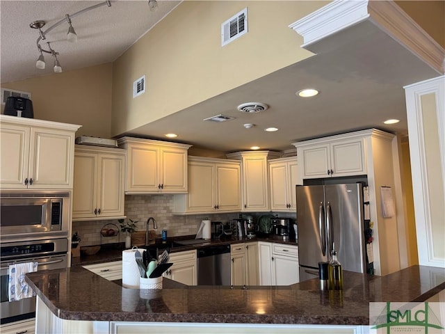 kitchen featuring visible vents, backsplash, appliances with stainless steel finishes, and a sink