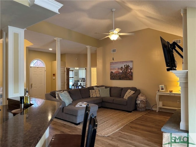 living room with visible vents, vaulted ceiling, decorative columns, wood finished floors, and a ceiling fan