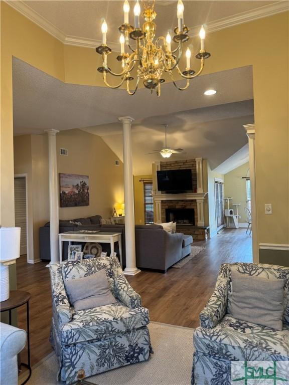 living area featuring a ceiling fan, crown molding, a fireplace, and ornate columns