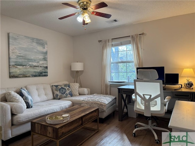 home office featuring ceiling fan, wood finished floors, visible vents, and a textured ceiling