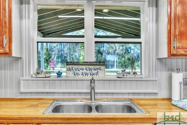 interior space with vaulted ceiling, butcher block counters, and a sink