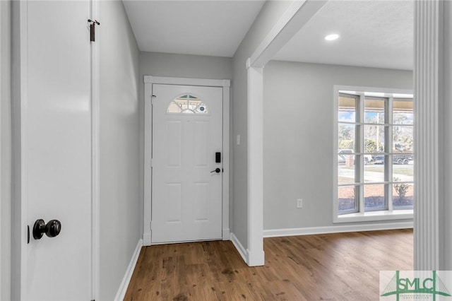 foyer entrance with baseboards and wood finished floors