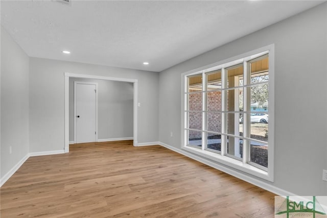 unfurnished room with recessed lighting, baseboards, and light wood-type flooring