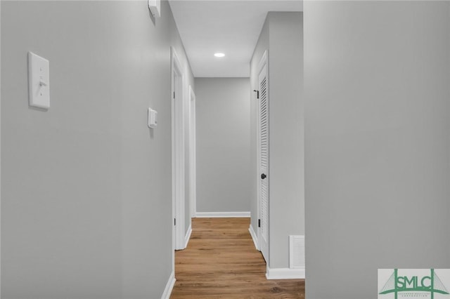 hall with recessed lighting, wood finished floors, and baseboards