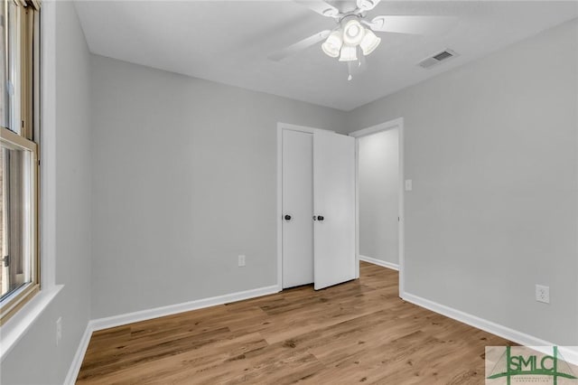 unfurnished bedroom featuring visible vents, baseboards, light wood-style floors, and a ceiling fan