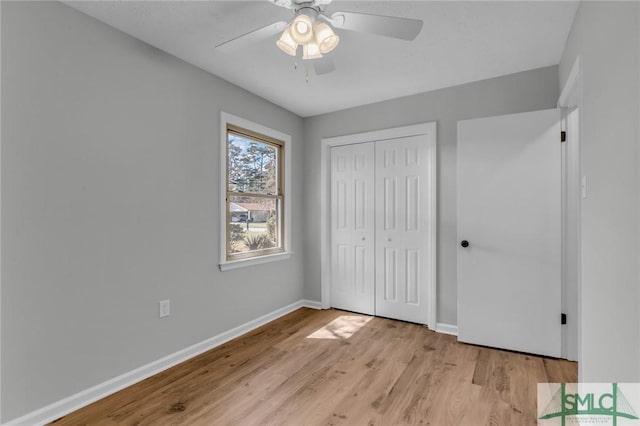 unfurnished bedroom featuring a closet, a ceiling fan, baseboards, and light wood finished floors