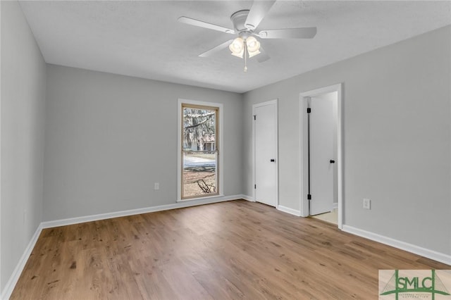 unfurnished bedroom featuring ceiling fan, baseboards, and wood finished floors