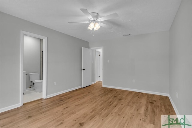 unfurnished bedroom featuring a ceiling fan, baseboards, visible vents, light wood finished floors, and ensuite bathroom