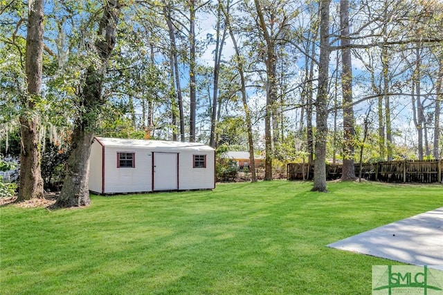 view of yard featuring a storage unit, an outdoor structure, and fence