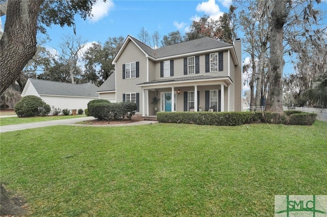 view of front of house with covered porch, a chimney, concrete driveway, and a front lawn