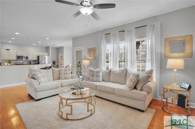 living room featuring recessed lighting, baseboards, light wood-style flooring, and a ceiling fan