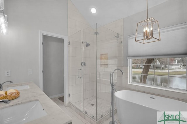 full bathroom with a shower stall, a freestanding tub, vaulted ceiling, and a sink