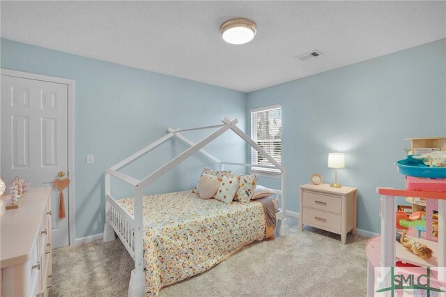 bedroom featuring carpet flooring, baseboards, visible vents, and a textured ceiling