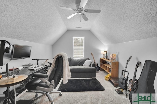 home office featuring visible vents, carpet floors, lofted ceiling, ceiling fan, and a textured ceiling