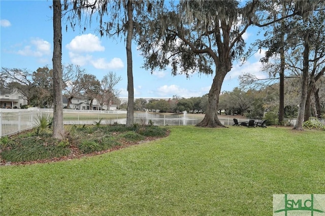 view of yard featuring fence and a water view