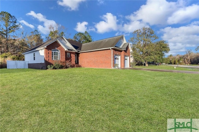 view of front of property featuring a front lawn, an attached garage, brick siding, and aphalt driveway