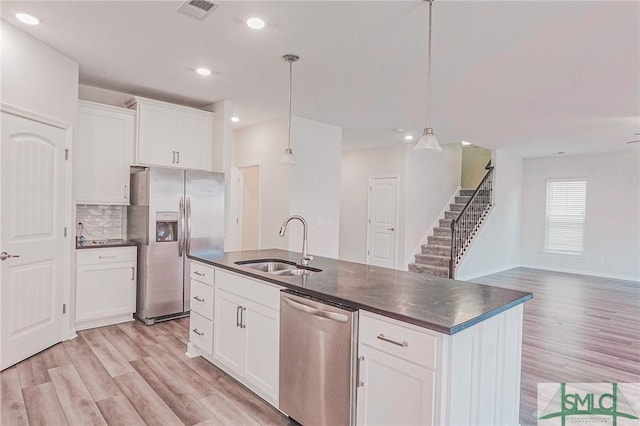 kitchen featuring a sink, visible vents, dark countertops, and appliances with stainless steel finishes