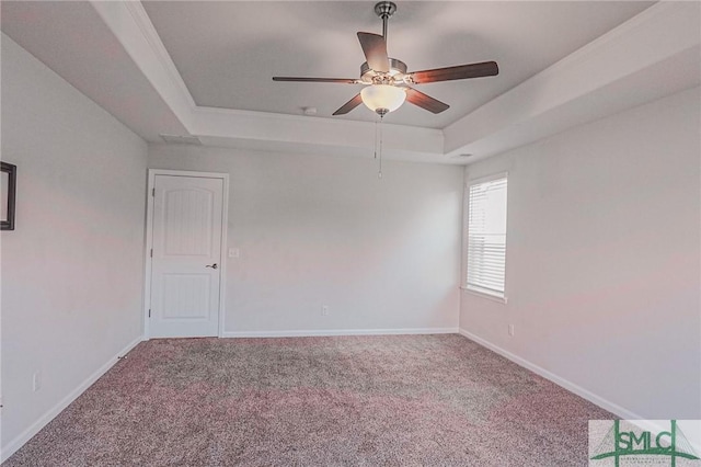 empty room with ceiling fan, baseboards, a tray ceiling, and carpet floors