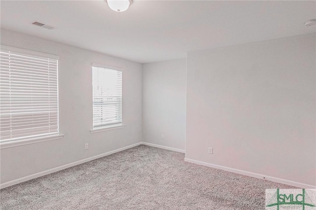 spare room featuring visible vents, baseboards, and carpet floors