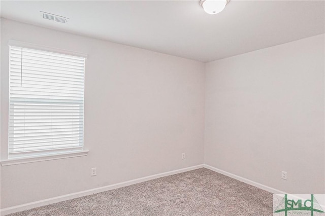 carpeted spare room featuring baseboards and visible vents