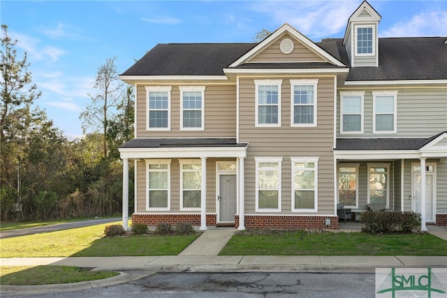 multi unit property featuring a front lawn, brick siding, and a shingled roof