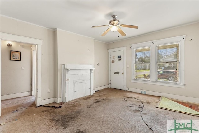 unfurnished living room with a ceiling fan, baseboards, carpet, and crown molding