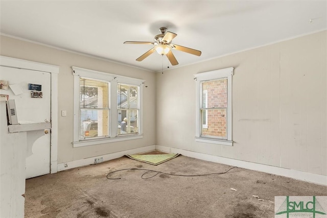 unfurnished room featuring a ceiling fan, ornamental molding, and carpet flooring