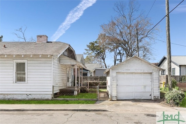 view of property exterior with fence, a chimney, a garage, an outdoor structure, and driveway