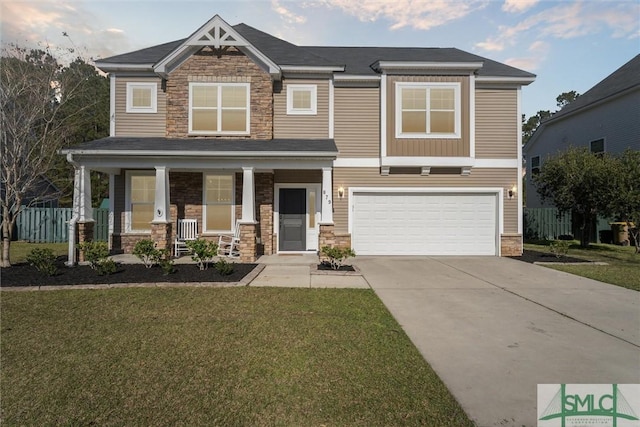 craftsman inspired home with a front lawn, a porch, driveway, stone siding, and an attached garage