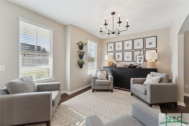 living area featuring wood finished floors, baseboards, and a chandelier