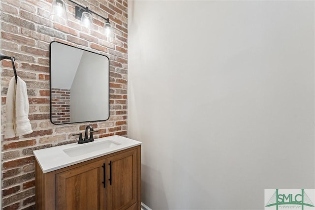 bathroom featuring brick wall and vanity