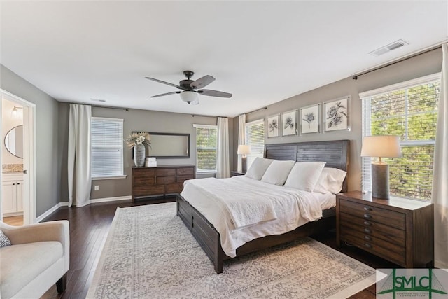 bedroom with visible vents, connected bathroom, ceiling fan, baseboards, and wood-type flooring