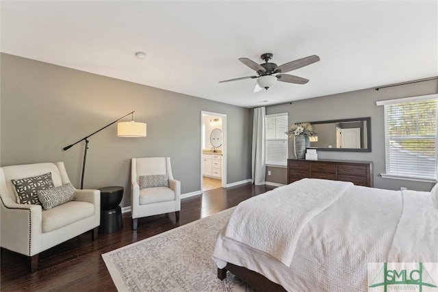 bedroom featuring dark wood-style floors, baseboards, ensuite bathroom, and ceiling fan