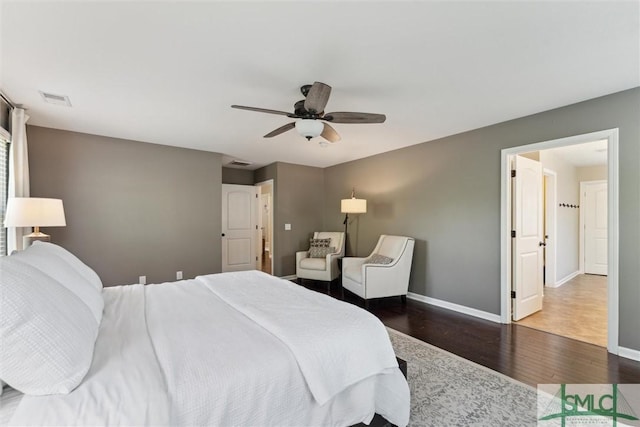 bedroom with visible vents, baseboards, wood finished floors, and a ceiling fan