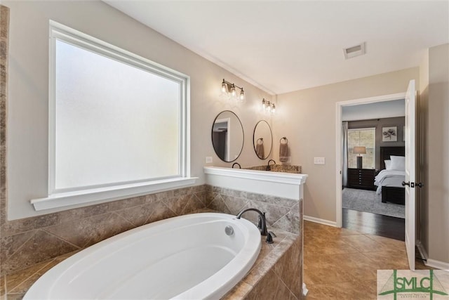 ensuite bathroom featuring baseboards, visible vents, tile patterned flooring, a bath, and connected bathroom